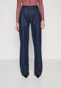 Navy blue leather trousers with a loose fit, featuring two front pockets and a button closure. Smooth texture with a relaxed silhouette.