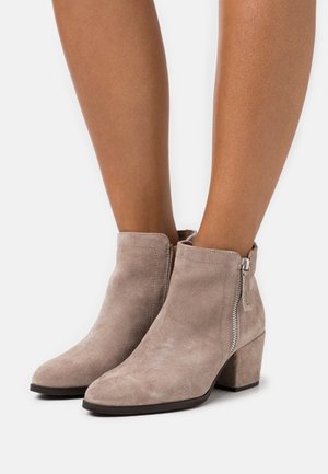 Béžové semišové kotníkové boty se špičatou špičkou a bočním zipem, s blokovým podpatkem a hladkou texturou.
