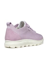 Sneaker viola chiaro con tomaia in tessuto testurizzato e tallone in suede liscio. Presenta una suola in schiuma bianca e ondulata e un linguetta sul retro.