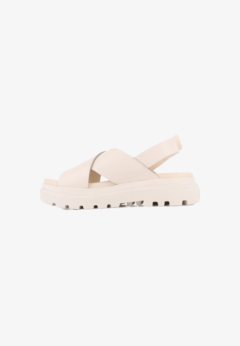 Light beige cross-strap sandals with a soft leather upper, cushioned footbed, and a textured white rubber sole featuring grip patterns.