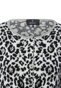 Leopard print sweater featuring a soft knit texture, cream base, black accents, and a gray neckline. Brand label "monari" visible.