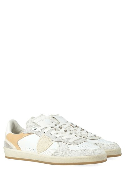 Sneakers bianchi in pelle con dettagli testurizzati, perforazioni e un pannello beige sul lato. Design con lacci e punta tonda.