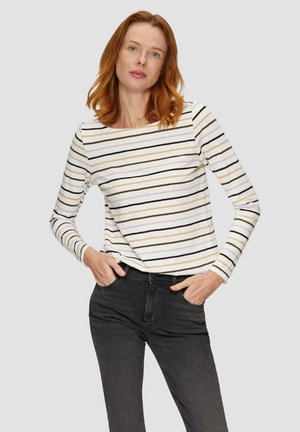 Haut à manches longues à rayures avec des lignes blanches, noires, grises et beiges. Tissu doux avec une coupe décontractée, associé à un jean gris foncé.