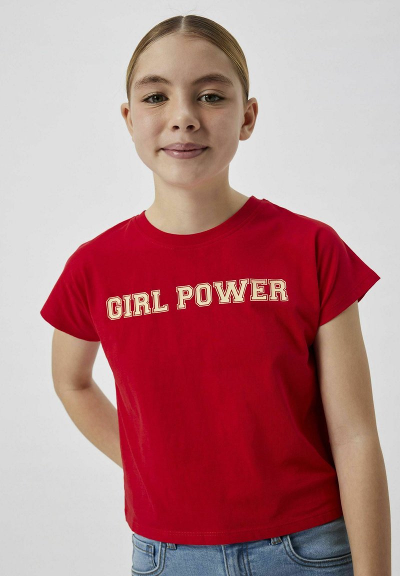 Röd bomullströja med korta ärmar och rund nacke, med texten "GIRL POWER" i krämfärgade blockbokstäver över framsidan.