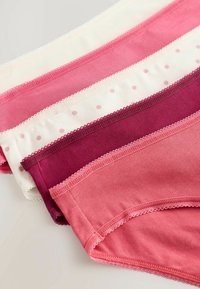 Vier paar damesondergoed in verschillende tinten roze en rood, met kant en stippenpatronen. Katoenen materiaal, zachte textuur.