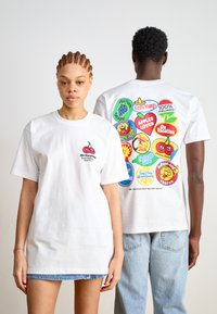 Hvite bomulls t-skjorter med korte ermer. Fronten har et lite kirseb�ærmotiv, mens baksiden viser fargerike frukt-tema design.
