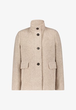 Beżowy, teksturowany płaszcz z polaru z kołnierzem stójkowym, zapięciem na guziki z przodu oraz dwoma naszytymi kieszeniami. Charakteryzuje się pudełkowym fasonem i miękkim wyglądem.