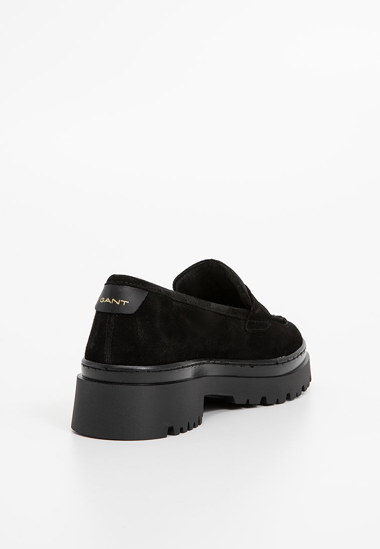 Schwarze Wildleder-Slipper mit einer klobigen schwarzen Gummisohle. Verfügt über minimale Nähte und einen goldenen Logoakzent an der Ferse.