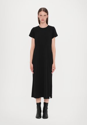 Black knee-length dress with short sleeves and a round neckline. Made of textured fabric with vertical seam details and side slits.