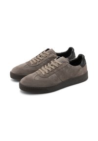 Sive sportske cipele od nubuk kože s smešnim gumenim đonovima, ravnim pertlama i crnim kožnim detaljima na peti. Zaobljen vrh i minimalistički dizajn.