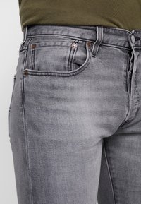 Grå denimjeans med slim fit, som har fem fickor, kopparfärgad hårdvara och subtila blekningar.