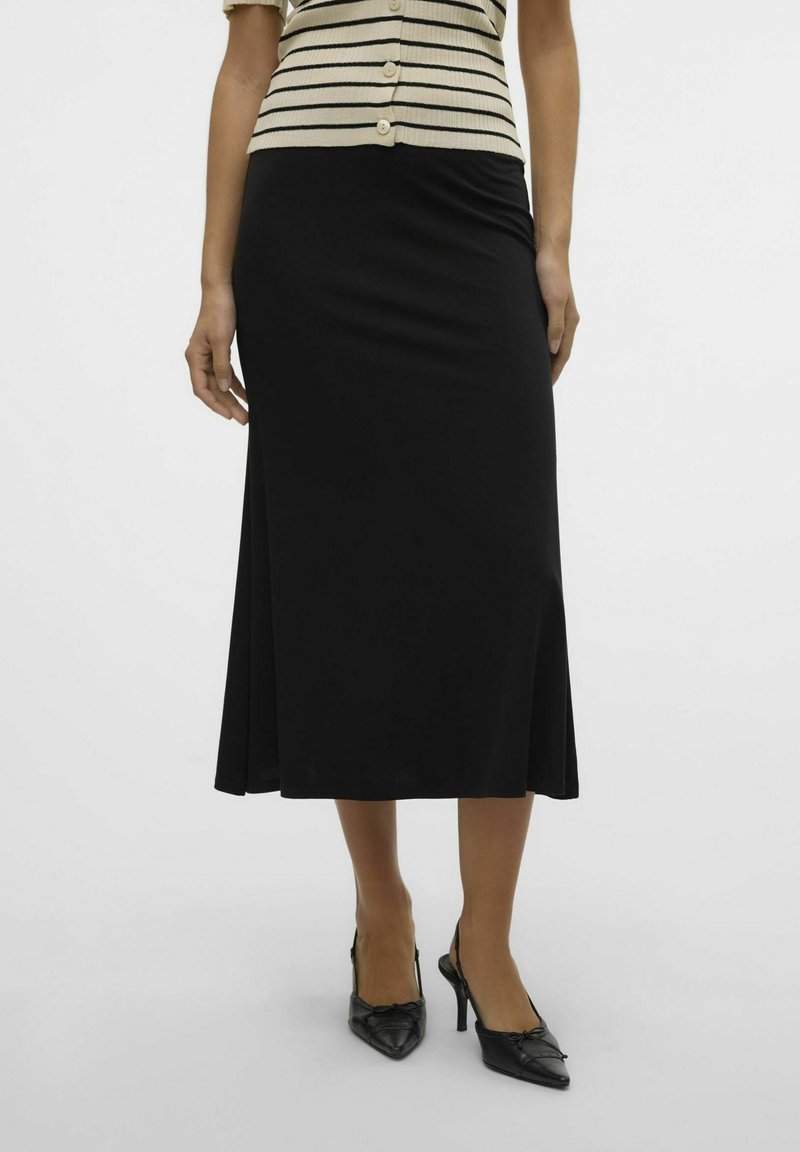 Črna midi krilo z razširjenim robom, izdelano iz gladkega blaga. Ujemajoče se z sandalnimi črnimi čevlji na peto in prugastim srajčnim topom.