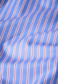 Plava tkanina s uskim okomitim prugama u bijeloj i crvenoj boji, glatke teksture, laganog sjaja, preklopljena da prikaže dimenziju i uzorak.