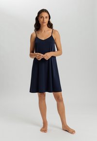 Abito slip blu navy con spalline sottili, realizzato in tessuto morbido, presenta una scollatura a V e un taglio largo e fluido che arriva sopra il ginocchio.