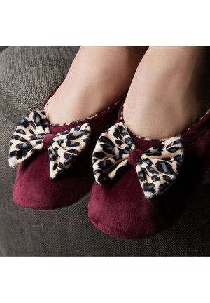 Chaussons en velours bourgogne avec de grands nœuds en tissu imprimé léopard à l'avant, dotés d'une doublure intérieure douce et d'un design à bout arrondi.
