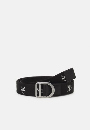 Black fabric belt with repeated white "ck" logo and silver D-shaped metal buckle on a plain background.