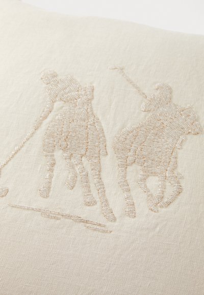Beige linen cushion featuring embroidered figures of two polo players, with detailed stitching and a textured, subtle pattern.