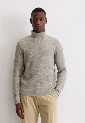 Hellgrauer, gerippter Rollkragenpullover aus weichem Strickstoff, mit langen Ärmeln und bequemer Passform, kombiniert mit cremefarbener Cordhose.