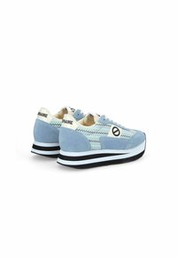 Blauwe suède sneakers met een gemêleerd geweven patroon, witte veters en een zwart-wit gestreepte zool. Merk op de hiel.