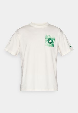 T-shirt bianco in cotone a maniche corte, con una stampa di tasca tie-dye verde recante il testo "CELTICS" e un logo a trifoglio. Logo Nike sulla manica.