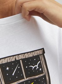 Camiseta de algodón blanca con mangas cortas, que muestra un diseño impreso de una ventana con estrellas, pájaros y estrellas fugaces sobre un fondo oscuro.