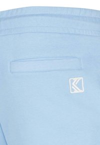 Joggers de color azul claro fabricados en una tela suave, con un pequeño logo blanco y un elegante bolsillo trasero con un contorno cosido.