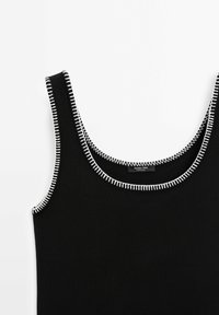 Débardeur en maille noir sans manches avec surpiqûres blanches contrastantes le long du col et des emmanchures.