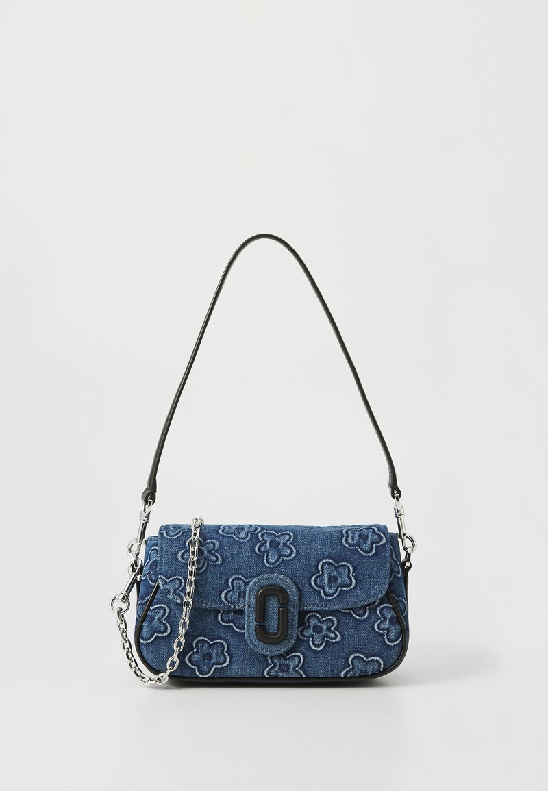 Bolsa de ombro em denim com bordados florais, alça de couro preta e detalhe em corrente prateada. Apresenta um fecho com aba e detalhe de logotipo da marca.