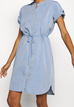 Robe bleu clair à manches courtes avec poignets retroussés, col mao, boutonnage frontal et taille ajustable par lien, portée par une personne debout.