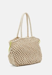 Sac fourre-tout en paille tissée beige clair avec un design en maillage ouvert et des accents vert citron. Poignées doubles en tissu pour une polyvalence de port.