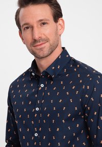Marine shirt met kleine oranje schakenstukken en trofee patronen, knoopsluiting ontwerp, lange mouwen en een kraag. Gladde stofstructuur.