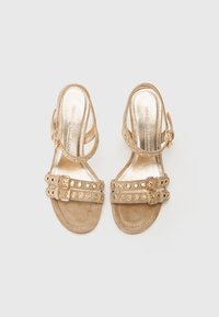 Goldfarbene Absatzsandalen mit Wildleder-Textur, doppelten Riemen mit runden Ausschnitten und einer verstellbaren Schnallenverschluss.