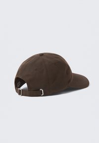 Καφέ βαμβακερό καπέλο με καμπυλωτό γείσο, ρυθμιζόμενο λουράκι με μεταλλική αγκράφα και ραμμένες λεπτομέρειες στην κορυφή και στο γείσο.