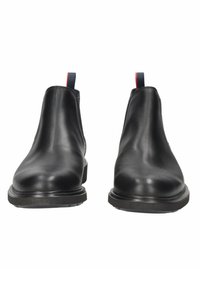 Stivaletti neri in pelle con punta arrotondata, pannelli laterali elasticizzati e una linguetta colorata sul retro, montati su una robusta suola in gomma nera.