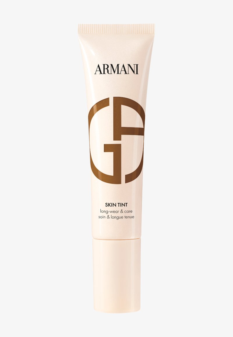 Armani Skin Tint i en beige klem tube med en blank finish. Har en fremtredende brun logo, merket for langvarig bruk og pleie.