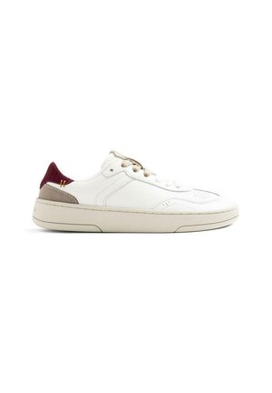 Sneaker bianca bassa con suola beige, stringhe beige e dettagli sul tallone in bordeaux e taupe, mostrata di profilo su sfondo bianco.