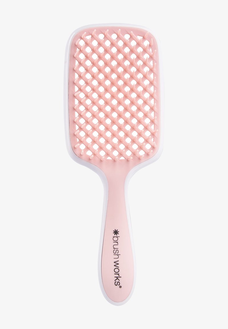 Brosse à cheveux rectangulaire avec un corps en plastique rose clair, un design en treillis pour les poils, et un bord en caoutchouc blanc pour une meilleure prise en main.