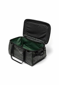 Sac de sport noir et vert avec un dessus zippé, extérieur en tissu présentant un motif subtil, texture lisse et deux poignées pour le transport.