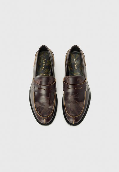 Bruine leren instaploafers met reliëfpatronen, contrasterende stiksels en een slip-on ontwerp. Voorzien van een patroon in de binnenzool en een ronde neus.