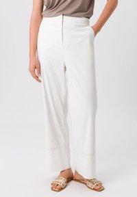 Witte wijde broek gemaakt van een gladde stof, met zijzakken en een nette zoom met subtiele stikdetails.