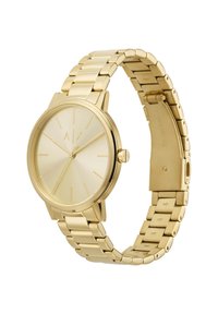 Montre en acier inoxydable doré avec un boîtier rond, un cadran minimaliste et un bracelet à maillons. Présente des initiales de marque gravées et une finition lisse.
