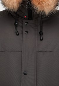Dark gray puffer jacket with a detachable light brown fur hood. Features black snap buttons and adjustable drawstrings at the collar.