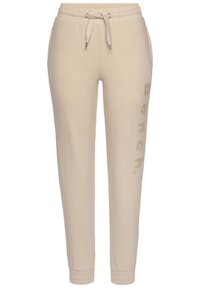 Beige Jogginghose aus weichem Material, mit einer Kordelzugtaille, Seitentaschen und dezent auf einem Bein aufgedrucktem "Bench." Logo.