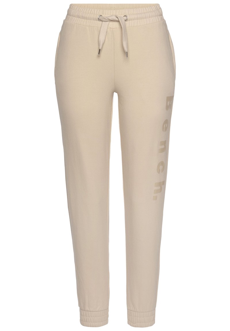 Beige Jogginghose aus weichem Material, mit einer Kordelzugtaille, Seitentaschen und dezent auf einem Bein aufgedrucktem "Bench." Logo.