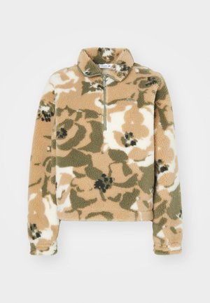 Fleece genser med halv-zip krage, med et blomstrete kamuflasjemønster i beige, olivengrønn og kremfarge. Myk tekstur og lange ermer.