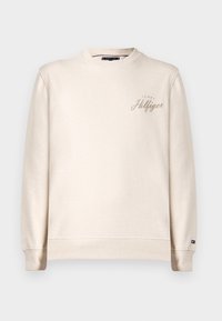 V krémszínű pulóver, kerek nyakkivágással, bordázott mandzsettával és szegéllyel, elöl diszkrét hímzett "Tommy Hilfiger" logóval. Puha tapintású.