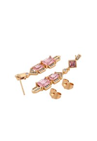 Aukso spalvos auskarai, puošti stačiakampiais ir kvadratiniais rožiniais akmenimis, dekoruoti mažais skaidriais kristalais ir unikaliais geometriniais raštais.