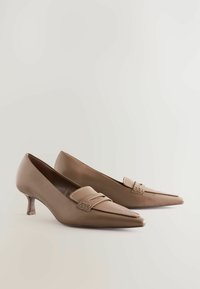Ruske nahkasaappad, millel on terav nina, madal konts ja dekoratiivne rihm. Sile tekstuur kerge läikega ja minimalistlik disain.