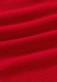 Heldere rode gebreide stof met een gestructureerd ribbelpatroon, die een zachte, dikke uitstraling toont in horizontale golven.