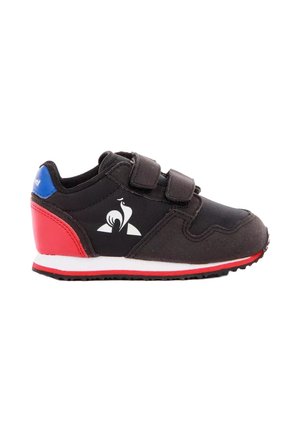 Zapatilla deportiva infantil negra con talón rojo, cuello azul, suela blanca, dos tiras de velcro y logo blanco de gallo en el lateral.